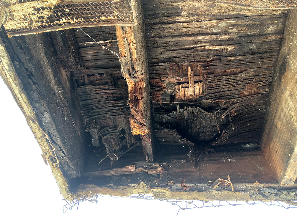 Closeup of underside of balcony requiring SB326 compliant repairs of exterior elevated wood elements