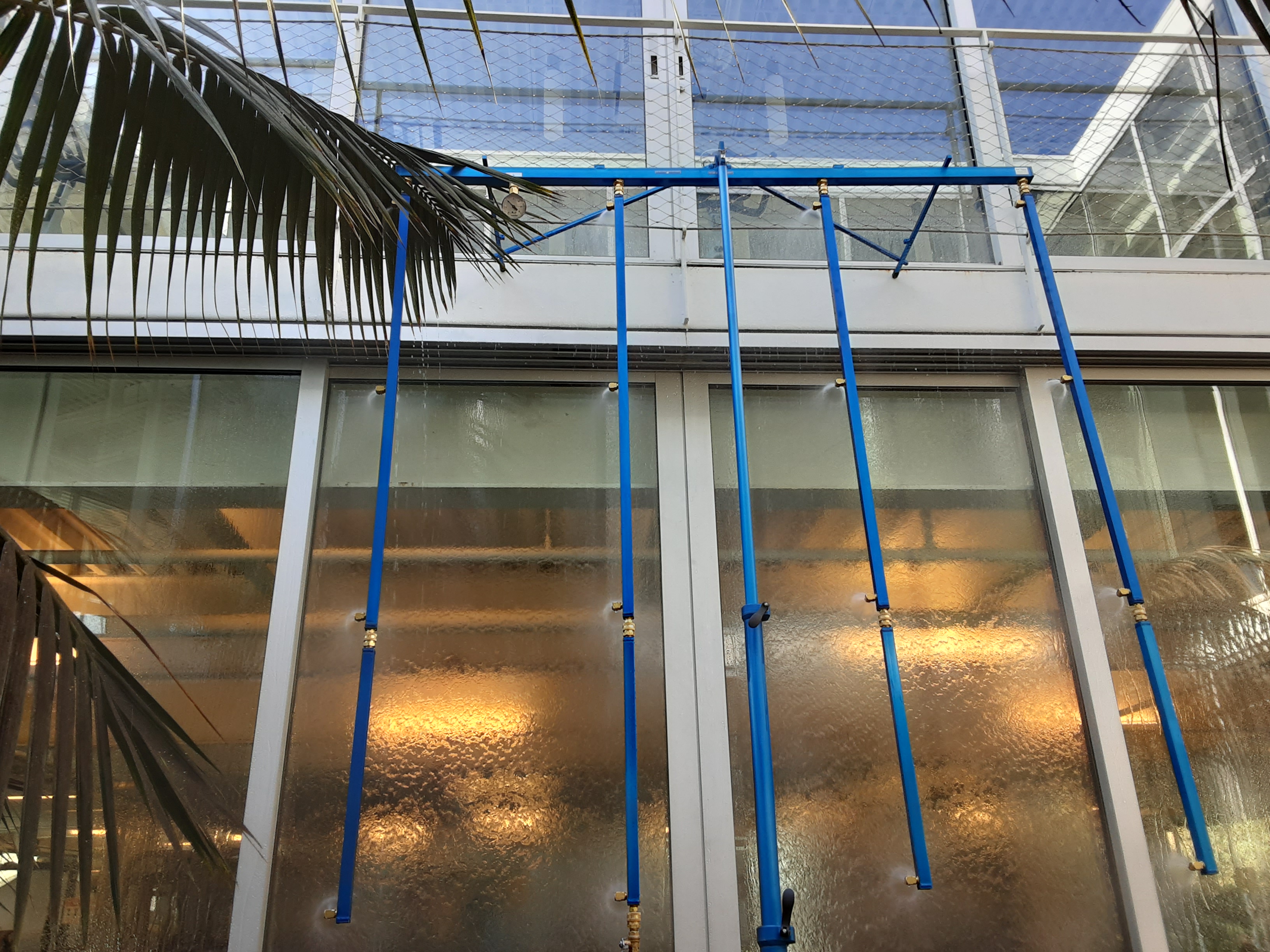 exterior of building with storefront windows getting sprayed for water testing